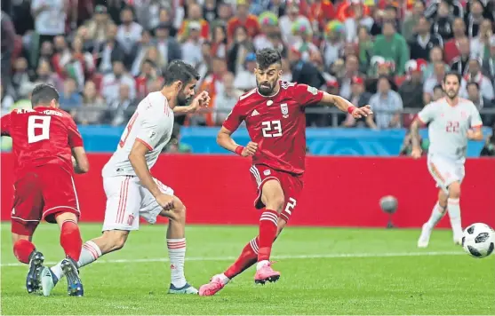  ?? Picture: AP. ?? Spain’s Diego Costa, second left, scores the winning goal past Iran’s Ramin Rezaeian, right, and Omid Ebrahimi.