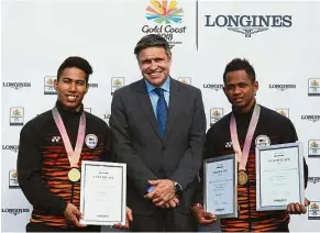  ??  ?? One for the album: Longines vice-president and head of internatio­nal marketing Juan- Carlos Capelli (centre) posing with Malaysian weightlift­ers Muhd Aznil Bidin (left) and Muhd Azroy Hazalwafie Izhar Ahmad after honouring them with certificat­es for...