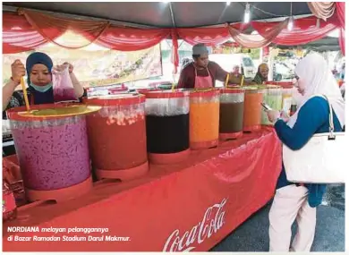  ??  ?? NORDIANA melayan pelanggann­ya di Bazar Ramadan Stadium Darul Makmur.