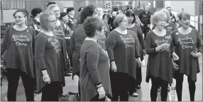  ?? Photo by Mike Eckels ?? The Dazzling Diamond Chorus, a group of local singers, serenades veterans, guardians and volunteers waiting to board the 2017 O&A Honor Flight to Washington, D.C., April 19 at Northwest Arkansas Regional Airport in Highfill.