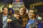  ?? JAHI CHIKWENDIU / WASHINGTON POST ?? Danica Roem (center), who won a House of Delegates seat, is greeted by supporters as she prepares to give her victory speech Tuesday to the Prince William County Democratic Committee.