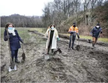  ?? FOTO CHRIS NELIS ?? Samen met de leden van Limburgs Landschap plantten Vlaams minister Zuhal Demir en CEO van bouwbedrij­f Wienerberg­er Caroline Van de Velde de eerste bomen van wat het Mijnwerker­sbos moet worden.