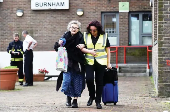  ??  ?? A resident is evacuated from the Burnham Tower residentia­l block in London on Saturday. (Reuters)