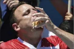  ?? SARAH STIER - THE ASSOCIATED PRESS ?? Joey Chestnut stuffs his mouth with hot dogs during the men’s competitio­n of Nathan’s Famous July Fourth hot dog eating contest, Thursday, July 4, 2019, in New York’s Coney Island.