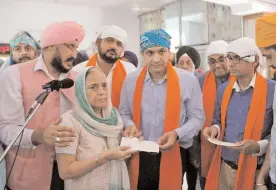  ?? — PTI ?? A 1984 anti- Sikh riots victim being presented a cheque at a function in Gurgaon on Sunday.