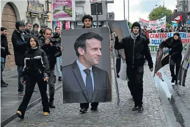  ?? MARCO BERTORELLO / AFP ?? Un grupo de jóvenes porta una imagen de Macron durante una marcha ecologista.