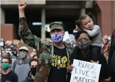  ??  ?? LOOK AT ‘SYSTEM OF RACISM’: Veteran John Griffith stands with his wife, Aina Adler, and daughter Lily, 2, at City Hall before marching to the Ruggles T station near police headquarte­rs to protest police violence on Sunday.