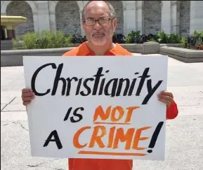  ??  ?? Christian campaigner: Rev Patrick Mahoney holds a placard protesting against the jailing of a pastor in Iran