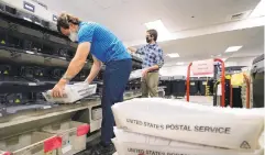  ?? MATT SLOCUM/AP ?? Kyle Hallman, left, and Michael Imms, with Chester County Voter Services, gather mail-in ballots being sorted for the 2020 general election in West Chester.