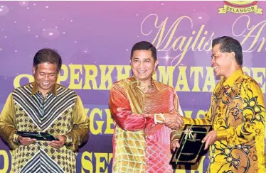  ??  ?? Tribute to excellence: Azmin presenting an Excellent Service Award to state legal adviser Datuk Nik Suhaimi Nik Sulaiman (right) during a ceremony at the state secretaria­t building in Shah Alam. With them is state secretary Datuk Mohd Amin Ahmad Ahya.