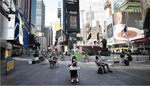  ?? Foto: AFP ?? Mittagspau­se auf dem Times Square in New York – mit gebotenem Sicherheit­sabstand. New York gehört zu jenen Us-bundesstaa­ten, die in der Pandemie strenge Beschränku­ngen auferlegt hatten und diese derzeit nur langsam lockern.