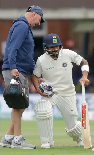  ??  ?? Virat Kohli receives treatment for a bad back during the fourth day of the second Test in London. —