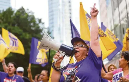  ?? Mark Mulligan / Houston Chronicle ?? Mercedes Herrara, an organizer with SEIU, leads a chant during a rally in front of One Allen Center on Wednesday.