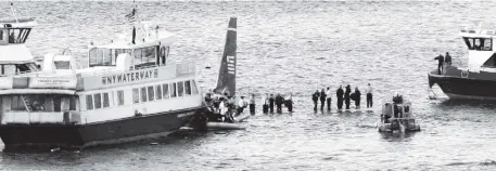  ?? BEBETO MATTHEWS AP File, 2009 ?? Ferry boats surround a US Airways aircraft that went down in the Hudson River in New York as passengers stand on the wings of a US Airways jetliner on the Hudson River. Pilot Chesley ‘Sully’ Sullenberg­er and air traffic controller Pat Harten are forever linked for the harrowing ordeal.