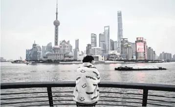  ?? HECTOR RETAMAL AFP/Getty Images/TNS ?? A youth looks at the skyline from the promenade on the Bund along the Huangpu River in Shanghai on Feb. 14, 2022.