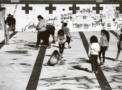  ?? Photos by Marie D. De Jesús / Staff photograph­er ?? Families spray paint in the outdoor pool at the Evelyn Rubenstein Jewish Community Center in Houston’s Meyerland neighborho­od Sunday during groundbrea­king celebratio­n events for new facilities.