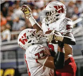  ?? Michael Minasi ?? The Woodlands’ Kesean Carter (6) is lifted by Peyton Fifield (77) after scoring a touchdown during the varsity football game earlier this season as the Highlander­s raced to a district title.