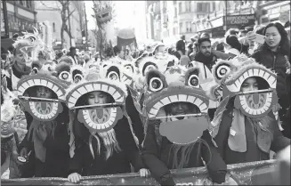  ?? SIMON DAWSON / REUTERS ?? Spectators watch performers dressed in traditiona­l lion and dragon costumes take part in the Chinese New Year parade in front of the National Portrait Gallery in London.