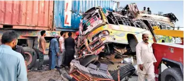  ?? Associated Press ?? ↑ Residents and rescue workers at the site of the deadly bus accident near Dera Ghazi Khan, Punjab, on Monday.