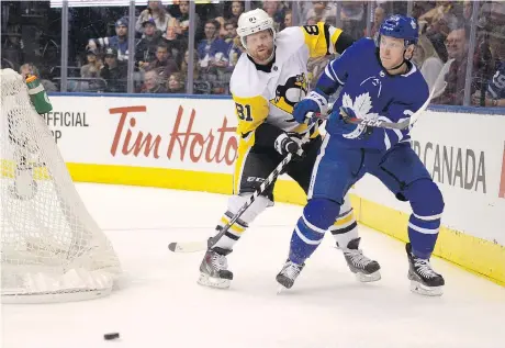  ?? JON BLACKER/THE CANADIAN PRESS ?? Pittsburgh Penguins right wing Phil Kessel fights with Toronto Maple Leafs defenceman Travis Dermott for the puck during Saturday’s game in Toronto. Kessel’s 77 points make him one of three Penguins in the NHL’s top 10 in scoring, but he’s nominally a...