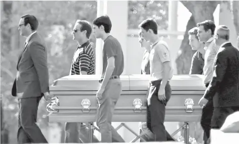  ?? ASSOCIATED PRESS ?? Family of Scott Beigel, the 35 year-old geography teacher who was killed during the Marjorie Stoneman Douglas High School shootings, escort his casket to the mausoleum after the service at Temple Beth El in Boca Raton, Florida.