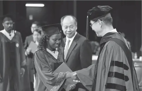  ?? PROVIDED TO CHINA DAILY ?? Brenda Fiona Kazule is congratula­ted by Professor Justin Yifu Lin, dean of the Institute of South-South Cooperatio­n and Developmen­t, Peking University as she receives her diploma in June, 2018.