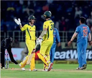  ?? AP ?? Australia’s Richardson (left) and Cummins celebrate after winning the first T20 against India. —