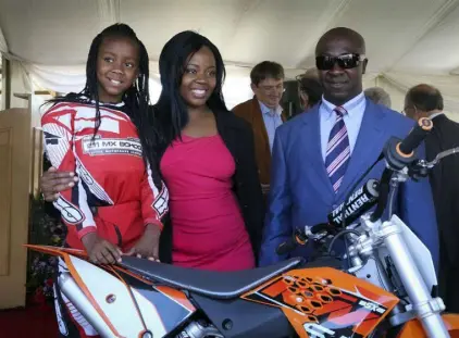  ?? ?? Tanya Muzinda with her parents, Adiyon and Tawanda Polycup Muzinda, as she receives a new bike sponsored by KTM Austria.