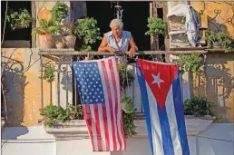  ?? Associated Press photos ?? In this file photo, Javier Yanez stands on his balcony decorated with U.S. and Cuban flags in Old Havana, Cuba.