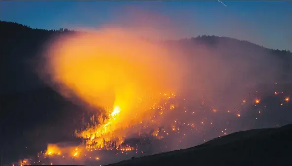  ?? — PHOTOS: THE CANADIAN PRESS ?? A wildfire burns Friday on a mountain near Ashcroft. More than 3,000 residents have been evacuated from their homes in central British Columbia. A provincial state of emergency was declared after 100-plus new fires started Friday.