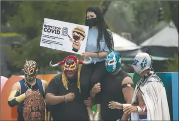  ??  ?? Lucha Libre fighters pose for a photo during a campaign to promote the use of masks during the covid 19 pandemic in Xochimilco.