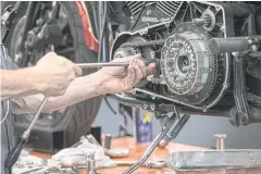  ??  ?? A worker uses a socket wrench to repair a Harley-Davidson motorcycle inside the service area at a dealership in Oakland, California on July 16, 2020.