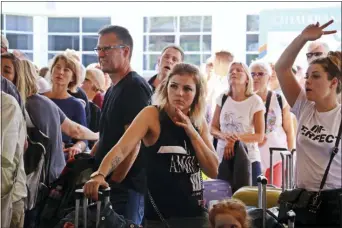 ?? IHA VIA AP ?? British passengers with Thomas Cook wait in queue at Antalya airport in Antalya, Turkey, Monday.