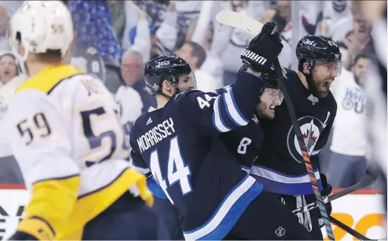 ?? TREVOR HAGAN/THE CANADIAN PRESS ?? Josh Morrissey, Jacob Trouba and Blake Wheeler celebrate one of Winnipeg’s seven goals in a win over Nashville on Tuesday to take the series lead.