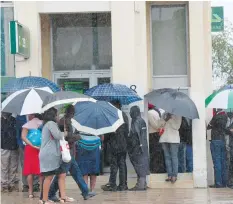  ??  ?? People queue to withdraw cash from a ZB Bank ATM in Mutare