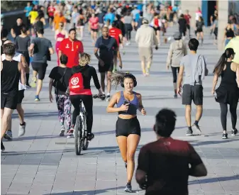  ??  ?? A seafront promenade in Barcelona, Spain, proves popular on Saturday, the first time residents were allowed out to exercise after seven weeks of confinemen­t in their homes.