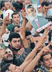  ?? Mohammed Saber European Pressphoto Agency ?? A PHOTO of ousted President Mohamed Morsi is raised at the Cairo funeral of seven protesters.