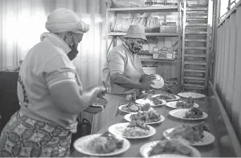  ??  ?? Volunteers at the Sincedeni Elderly Centre prepare meals with food rescued by Chefs with Compassion in Eldorado Park, Johannesbu­rg.