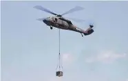  ?? Ned Gerard/Hearst CT Media file photo ?? A Sikorsky UH-60A Black Hawk helicopter hovers with a payload at Sikorsky Memorial Airport in Stratford in July.