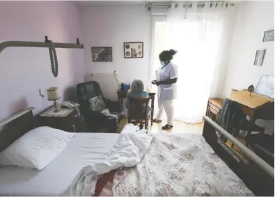  ?? JOEL SAGET / AFP VIA GETTY IMAGES ?? A nurse speaks to a resident in her bedroom at a seniors home in Paris. Occupancy levels are falling at many senior communitie­s and nursing homes as potential residents shy away from facilities that have been ravaged by the virus.