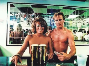  ?? COLORADOAN ARCHIVE ?? A waitress and “token male waiter” pose on opening day at Debbie Duz Donuts on July 29, 1989.