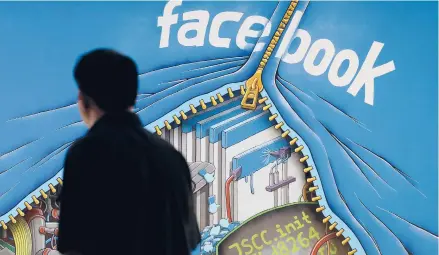  ?? JEFF CHIU/AP ?? Federal regulators asked Wednesday for Facebook to be ordered to divest its Instagram and WhatsApp services. Above, a man walks past a mural in an office on the Facebook campus in Menlo Park, California.