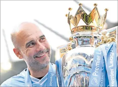  ?? ?? Guardiola coge en brazos el trofeo de campeón de la Premier League.