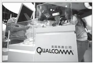  ?? AP file photo ?? Visitors look
at a display booth for Qualcomm at the Global Mobile Internet Conference in Beijing in April. Rival chipmaker Broadcom has increased its buyout offer for Qualcomm to more than $121 billion in what Broadcom calls its “best and final” offer.