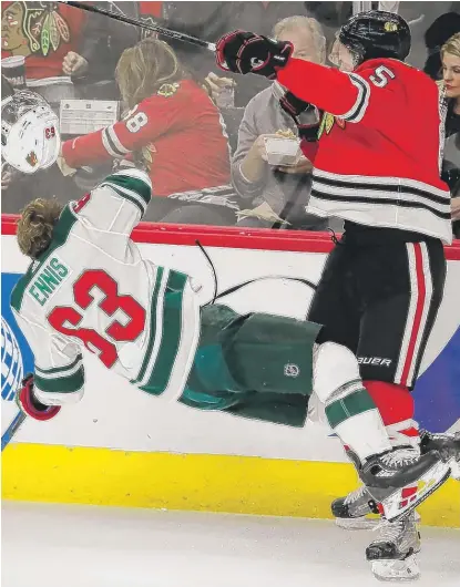  ?? | JIM YOUNG/ AP ?? The Wild’s Tyler Ennis loses his helmet as he collides with Blackhawks defenseman Connor Murphy in the first period.