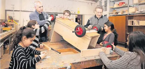  ?? FOTO: VEREIN ?? Georgios Pimenidis (Leiter Zentrum Plus Flingern/Düsseltal, l.) und Günter Friedeler vom Keywork-Verein helfen den Schülern beim Bau einer Seifenkist­e.