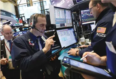  ?? (Brendan McDermid/Reuters) ?? TRADERS WORK on the floor of the New York Stock Exchange last Friday. Of 25 US companies seen by Credit Suisse as most exposed to a trade war, more than half will report their results this week.