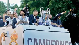  ?? AP ?? Real Madrid players arrive at the Cibeles square in Madrid on Sunday on an open-topped bus to celebrate their Champions League triumph.