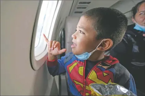  ??  ?? Yancarlos Amaya, 5, a migrant from Honduras, looks out an airplane window in Harlingen, Texas, as he and his mother, Celestina Ramirez, ride on an airplane to Houston on March 24. The mother and son, who were headed to Baltimore to reunite with Ramirez’s brother, were permitted to stay in the U.S. after turning themselves in to U.S. Customs and Border Protection upon crossing the border.
(AP Photo/Julio Cortez)