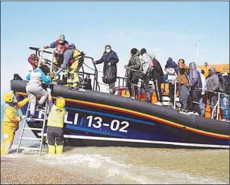  ??  ?? A group of people thought to be migrants are brought ashore from the local lifeboat at Dungeness in Kent, after being picked-up following a small boat incident in the Channel, England, Tuesday, Sept 7. (AP)